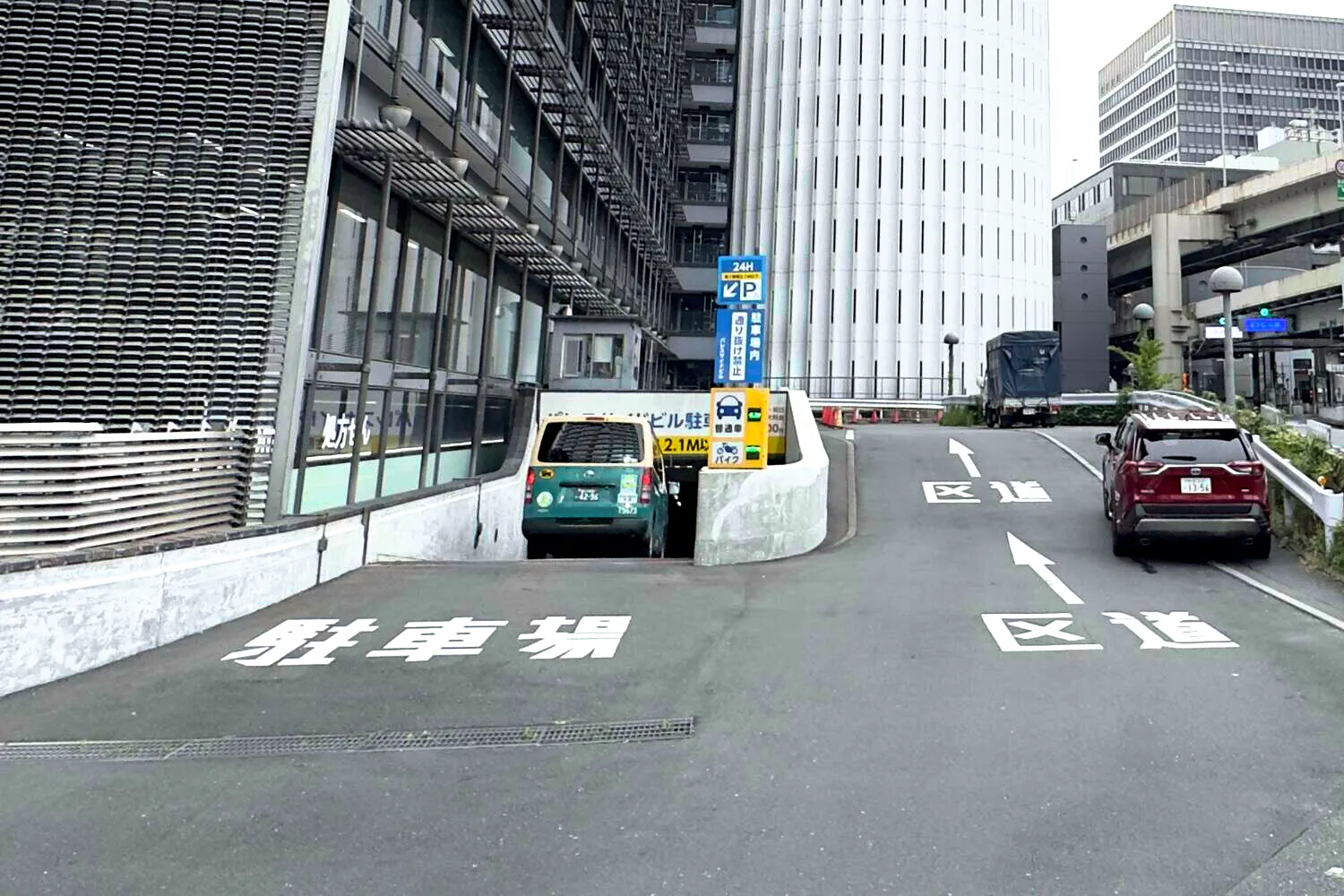 ビル東側（平川門側）の地下駐車場入口。青いPサインと路面の駐車場表示が目印