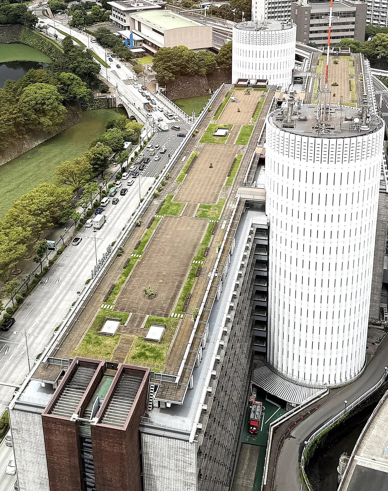 上空から見た屋上庭園。二つの白い円筒コアと、皇居のお濠・緑が連なる