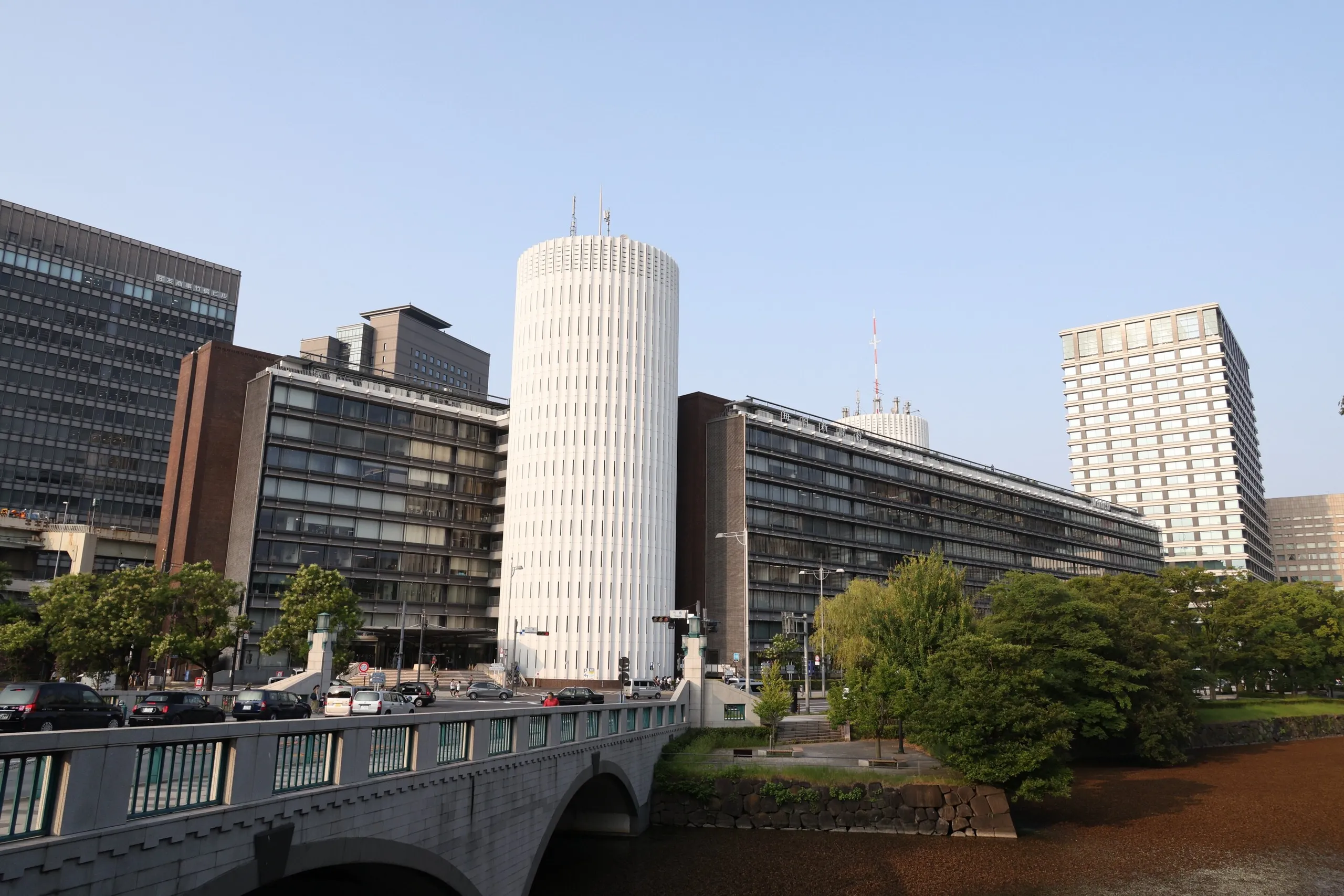 皇居のお濠側から見たパレスサイドビルの長い水平棟と白い円筒コア